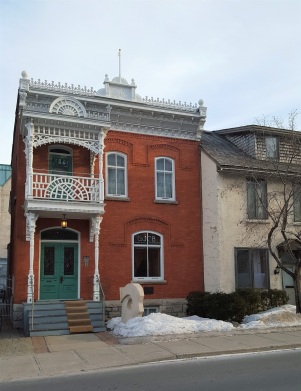 I couldn't find any information about the history of this building. It is a Victorian era home and has some pretty neat Eastlake style elements with the roof line and the second story balcony. The building is currently the home of a art gallery: Jean Claude Bergeron.